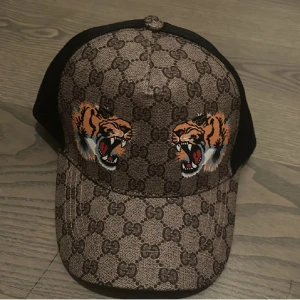 Snygg beige keps med ikonisk logga  - Snygg beige keps med ikonisk logga, bra kvalité.