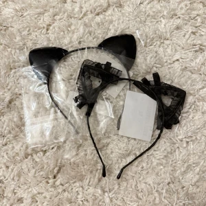Svart diadem med kattöron - Två snygga svarta diadem med kattöron, ena med spetts och rosetter och andra basic. Du får båda för 25kr. Säljer då det inte kommit till användning 
