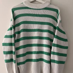 Tjocktröja med vita/gröna ränder - Så mysig tjocktröja i gröna/vita ränder, och slits på vardera sida nertill💚 Använd några gånger men i väldigt bra skick! Är stor i storleken så passar både XS, S och M, beroende på hur man vill att den ska sitta på
