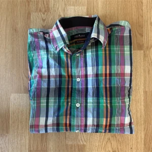 Färgglad rutig skjorta  - Snygg skjorta från Park Lane med ett färgstarkt rutigt mönster i grönt, blått, lila, orange och vitt. Skjortan har klassisk krage, knappar framtill och långa ärmar. 