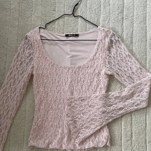 Ljusrosa spetsblus från Gina Tricot - Säljer en ljusrosa blus från Gina Tricot i storlek XS. Blusen har långärmade spetsärmar och ett genomgående spetsmönster över hela toppen. Rundad halsringning och figurnära passform. Säljer då den inte kommer till användning💗