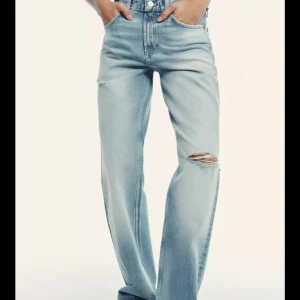 Ljusblå wide jeans med slitningar - Snygga ljusblå jeans med breda ben och slitna detaljer på låret och knät. Jeansen har en avslappnad passform och är tillverkade i denim för en cool och trendig look.