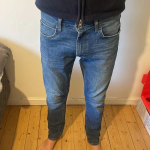 Blå skinny jeans från Lee - Säljer ett par blå skinny jeans från Lee med klassisk femficksdesign och snygga slitningar. Jeansen har normal passform i midjan och smalare ben, perfekt för dig som gillar en modern look. Materialet är mjukt jeans i bomull med lite stretch för extra komfort.