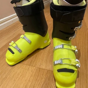 Gula skidpjäxor Head med spännen 40-41  - Säljer ett par coola skidpjäxor från Head i neon-gult och svart. De har fyra metallspännen och robust konstruktion för bra stöd i backen. Insidan är vadderad för extra komfort och yttermaterialet är slitstarkt syntet. Perfekt för dig som vill sticka ut i skidbacken!