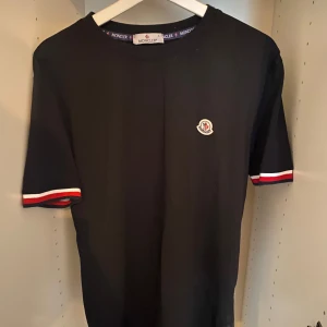 Svart Moncler t-shirt  - Svart t-shirt från Moncler i bomull. Bra skick då den knappt är använd. Qr kod funkar. Vid frågor skicka ett meddelande.