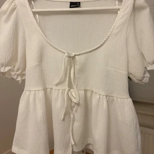 Vit blus från Gina  - Vit blus med knytning och volanger. Använd några gånger 