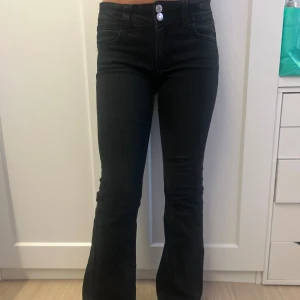 Svarta bootcut jeans från Gina Tricot  - Snygga svarta jeans från Gina tricot med bootcut passform och hög midja. Jeansen har två silverfärgade knappar fram, klassiska bakfickor med detaljer är gjorda i stretchigt jeansmaterial för en skön och smickrande siluett. Det är i storlek 152. Det går att buda på ❤️Passar även folk i storlek 32 i jeans. 