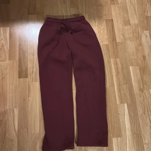 Vinröda mjukisbyxor från Gina Tricot XS - Vinröda mjukisbyxor från Gina Tricot i storlek XS. Byxorna har resår och snörning i midjan samt raka ben. Tillverkade i mjukt bomullsmaterial, perfekta för chill dagar. Enkel och stilren design utan tryck eller mönster.