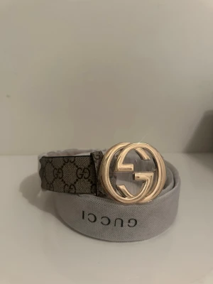  bälte med guldspänne - Säljer ett snyggt  bälte med klassiskt guldigt spänne. Bältet har det ikoniska bruna mönstret och är tillverkat i slitstark canvas med detaljer i skinn. Perfekt accessoar för att lyfta din outfit.