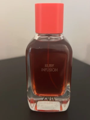 ZARA Ruby Infusion parfym - Stilren parfym från ZARA med modern design och röd kork. Perfekt för dig som vill sticka ut med en trendig flaska i väskan eller på hyllan. Namnet Ruby Infusion ger en exklusiv känsla.