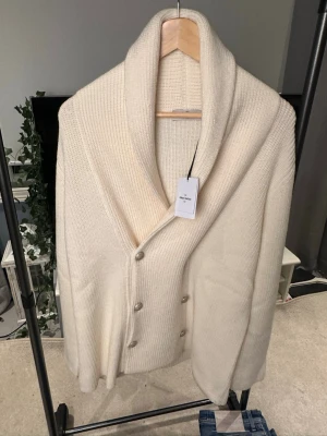 GRAN SASSO CARDIGAN - BRAND NEW! - Säljer en stilren vit cardigan jacka från Gran Sasso med bred krage och snygga knappar framtill. Jackan är grovstickad i mjuk ull och har långärmad design. Perfekt för dig som gillar klassisk och clean look.