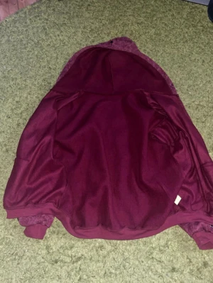 Röd fluff tröja - Röd tröja med kors på. Fluff på luvan går att ta av och sätta på.