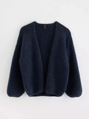 Mörkblå stickad kofta - Mysig mörkblå stickad kofta med avslappnad passform och lång ärm. Perfekt att slänga på sig över en t-shirt eller topp för extra värme. Enkel och stilren design utan knappar eller dragkedja.