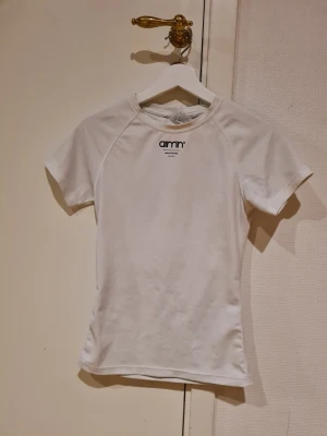 Aimn tränings t-shirt - Det är den äldre modellen som inte längre säljs med träningsmaterial. En liten bit missfärgad, inte lika vit som från början