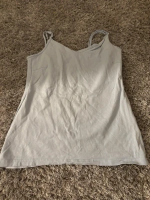 Ljusblått linne från lager 157, Storlek L  - Enkel och stilren ljusblått linne från lager 157 med smala axelband och mjuk känsla. Toppen är tillverkad i bomull med lite stretch för extra komfort. Perfekt att matcha med jeans eller shorts under varma dagar.