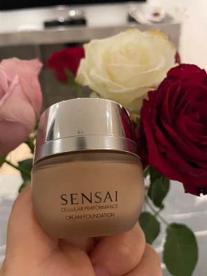 Sensai Cream Foundation - Sensai Cellular Performance Cream Foundation, färg CF24 Amber Beige  En vårdande creme foundation som döljer mörka fläckar, matthet och ojämn hudton för en sublim finish och lyster. Innehåller exklusiva anti-ageing ingredienser för en uppstramande och återfuktande effekt. •SPF 15 •Creme foundation med 80% fuktinnehåll. •Smälter lätt in i huden och gör huden slät och silkeslen.  •Till alla hudtyper Nypris: 1075kr  Ca 90% kvar.