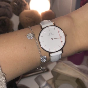 Daniel Wellington klocka Classic Petite  - Superfin klocka från Daniel Wellington, aldrig använd så plastskyddet e kvar på uret. Nypris ca 2000kr, mitt pris: 300kr. Vitt band med gulddetaljer💋