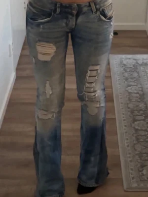 Diesel  ljusblå ripped jeans - Säljer ett par ljusblå jeans från Diesel med slitna och trasiga detaljer på benen. De är ett var lågmidjade jeans me utsvängda ben. Har varit mina favorit jeans länge men dem har tyvärr blivit för små för mig och säljer därför vidare💕