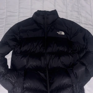 The North Face 700 Pufferjacket - Kom med pris själv. Säljer en svart pufferjacka från The North Face i storlek S. Jackan har hög krage, dragkedja framtill och klassisk logga på bröstet och ryggen. Perfekt för vintern och man inte kommer behöva tänka på att frysa 
