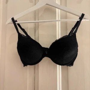 Svart spets-bh från Lindex 75C - Säljer en svart bh från Lindex, i modellen Linnea och i storlek 75C. Bh:n har tunna axelband och är täckt med snygg spets som ger en elegant look. Perfekt för dig som gillar klassisk stil med en twist. Mjuk och bekväm passform.