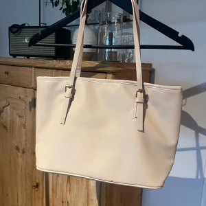 Ljusrosa väska  - Ljusrosa väska, den är rymlig med små fickor i. Den är lite trasig vid bandet som man ser på andra bilden 