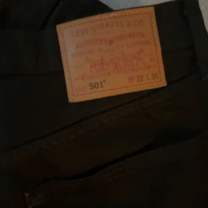 Svarta Levi's 501 jeans - Svarta klassiska Levi's 501 jeans med rak passform. Ikonisk läderpatch bak i midjan och femficksmodell. Jeansen är tillverkade i slitstarkt denim och har en tidlös look som funkar till allt. Perfekta för dig som gillar en clean och enkel stil.|  W32 L30| Pris kan diskuteras