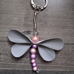 Reflex fjäril nyckelring  - Skapad av reflexpärlor i rosa och lila samt vingar gjorda av reflextyg. Fjärilen är ca 5.5cm. Blir en söt accessoar till tex väskan 