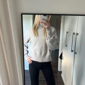 Beige stickad tröja - Mysig beige stickad tröja med hög krage och långa ärmar. 