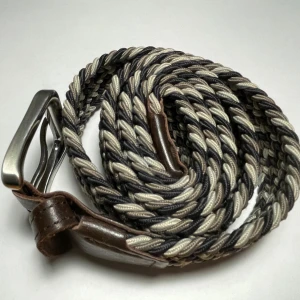 Flätat bälte från Jack & Jones - Snyggt flätat bälte från Jack & Jones i brunt, beige och svart. Bältet har detaljer i brunt skinn och ett robust metallspänne. Perfekt accessoar för att lyfta din outfit med en cool och avslappnad stil.