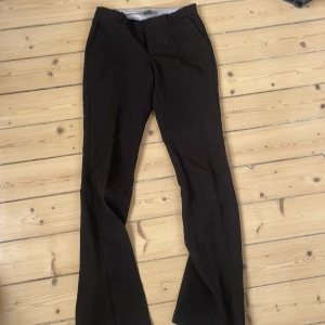 Svarta kostymbyxor från Neo Noir - Snygga svarta kostymbyxor från Neo Noir med klassisk passform och vida ben. Byxorna har hällor för bälte och stilren design, perfekta för en clean och dressad look. Materialet känns mjukt och följsamt.