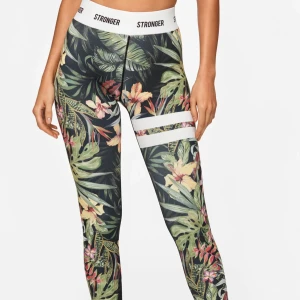 Stronger leggings med tropiskt mönster - Super fina träningsbyxor från Stronger med tropiskt blommigt mönster i storlek Small. Perfekt om du går på gymnastik! Säljer då jag vuxit ur de🫶