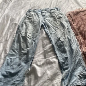 Ljusblå baggy jeans från Karl Kani - Säljer ett par ljusblå baggy jeans från Karl Kani med flera fickor och broderad logga på bakfickan. Jeansen har en avslappnad passform och är tillverkade i bomull. Perfekta för en streetwear-look.