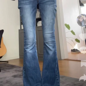 Blå flare jeans 💙💙 - Säljer ett par snygga blå jeans från lindex med klassisk bootcut/flare-passform. Jeansen har en lätt tvättad look med slitningar och är tillverkade i mjukt denimtyg. Perfekt nu inför hösten🧡🍁