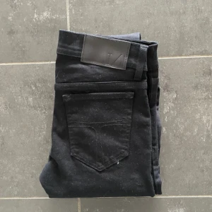 Svarta Slim jeans från Tiger of Sweden - Säljer ett par svarta jeans från Tiger of Sweden. Dem är Slim och är i mycket bra skick. Storleken är 28/32. Om ni undrar något så är det bara att fråga.