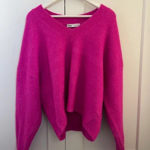 Oversized rosa stickad tröja Zara - Supermjuk och oversized stickad tröja från Zara i en stark rosa färg. Tröjan har v-ringad halsringning och långa ärmar