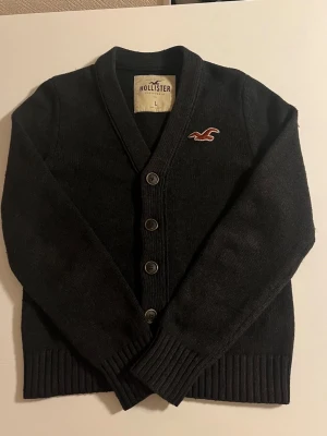 Hollister kofta svart passar som S  - Riktigt snygg kofta från Hollister i svart färg. Står L men passar storlek S 168-178 cm lång. Fint skick 8/10 pris 518 kr ej hugget i sten vid snabb affär kolla även mina andra annonser för mer mer och rabatt 😃