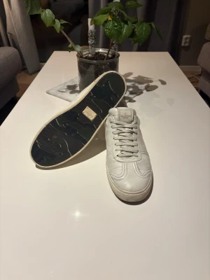 Valentino flycrew  -  Stilrena och tidlösa sneakers från Valentino, passar både vardag och mer uppklädda outfits.  Skick: Använda men i bra skick. lättare veck på lädret (se bilder). Inga större skador.             Detaljer: 	•	100 % original Valentino Garavani 	•	Färg: Vit 	•	                                                        Material: Läder 	                                                        pris går att diskutera!