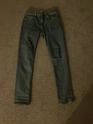 Blå  jeans från Gant - Säljer ett par klassiska blå jeans från Gant med en bra passform mellan straight och slim men mer åt det slima hållet passform. Jeansen har fem fickor, bälteshällor och dragkedja med knapp. Perfekta för dig som gillar en smal siluett och tidlös stil. Materialet är jeans och färgen är mörkblå. Jag är 164 cm och passar perfekt