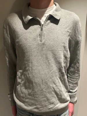Grå långärmad tröja med half zip - En stilren grå långärmad tröja med krage och half zip framtill. Tröjan har en klassisk passform och är tillverkad i ett mjukt material som känns skönt mot huden. Perfekt för lager-på-lager och funkar året runt.modellen är 184, tveka inte på att höra av er vid frågor! Pris kan diskuteras vid snabb affär😀