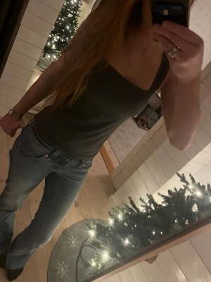 Mörkgrått/grönt kantigt linne - Snygg tröja med breda axelband och rak halsringning. Toppen är figurnära och har en stilren, enkel design som passar perfekt till jeans. Materialet känns mjukt och följsamt mot kroppen. Använts ett fåtal gånger