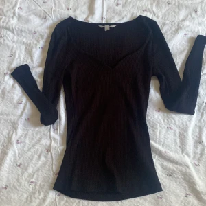 Svart tröja - En svart tröja med sweatheart neckline från H&M, ribbad och i storlek XS i färgen Svart.