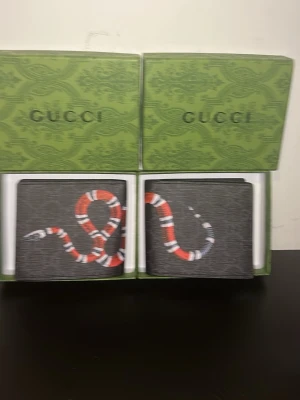 Svart Gplånbok med ormtryck - (Du får bara en plånbok) Svart plånbok med trendigt ormtryck i snyggt texturerat material. Stilren och lyxig känsla, perfekt för vardag och fest. Bra skick!