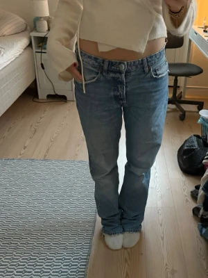 Ljusblå jeans från Zara - Säljer ett par ljusblå jeans från Zara i rak/mer baggy modell med låg midja. Klassisk femficksdesign och snygg tvätt. Jeansen är i bomull och har en avslappnad passform som ger en chill vibe.