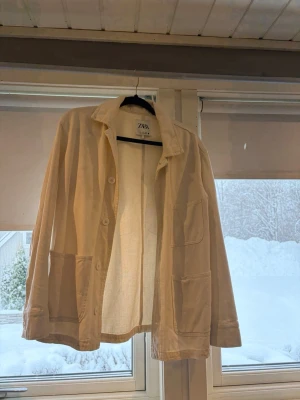 Beige overshirt från Zara - Säljer en beige overshirt/jeansjacka från Zara i storlek XS. Passar även S och M då den är större i storlek. Jackan har en avslappnad passform, stora utanpåfickor framtill och stängs med knappar. 