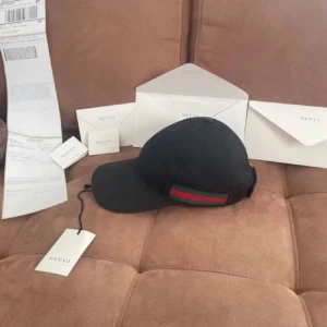 Gucci keps - Nyskick, använd ett fåtal gånger och det medföljer frakt papper och allt på bilden. Tveka inte på att höra av dig vid några funderingar!