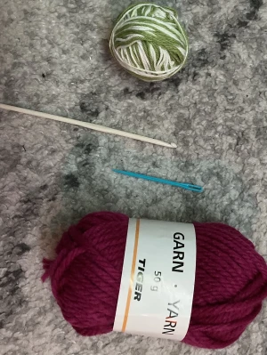 Garn med tillbehör  - Säljer 2 Garn ett lila 50 g och ett vitt o grönt. Med en plast nål och en 3,5 mm virknål. Frakten är ca 22-100kr beroende på vikten på produkten . Kontakta mig om du vill köpa.