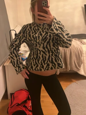 Zebramönstrad stickad tröja JDY XS - Säljer en stickad tröja från JDY i storlek XS med zebramönster i svart och beige. Tröjan har lång ärm, rund hals och en lite loose passform. Perfekt för dig som vill sticka ut med ett djurmönster i garderoben. Färgen grön och ljus beige 