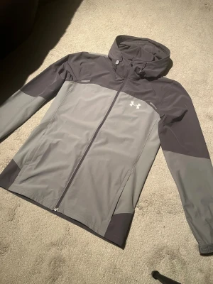 Under armor vindjacka - Skön vindjacka i bra skick, helt ny dok prislapp borttagen. Storlek S. Köpt på JD sports. Skriv vid frågor!