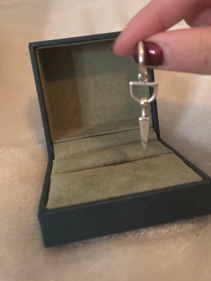 Snygg silverfärgad örhänge Maria Nilsdotter kosta nytt pris 2300kr -  Kan diskutera pris Unikt örhänge från Maria Nilsdotter i silverfärg. Hängsmycket har en spetsig, stilren design med ring och geometriska detaljer. Perfekt accessoar för dig som gillar edgy och minimalistisk stil. kostar nypris 2300 kr