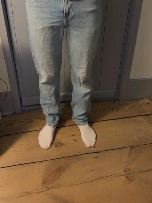 Ljusblå relaxed fit jeans från H&M - Säljer ett par ljusblå jeans från H&M med relaxed fit. Klassisk femficksmodell och raka ben. Jeansen är tillverkade i bomull och har en avslappnad passform som ger en chill vibe. Perfekta till sneakers eller boots.